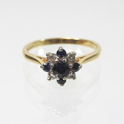 Lot 19 - An 18 carat gold sapphire and diamond cluster ring