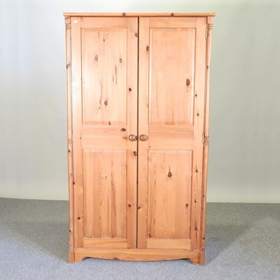 Lot 370 - A modern pine double wardrobe, with panelled...