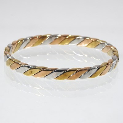 Lot 35 - A 9 carat three colour gold bangle, of hinged...
