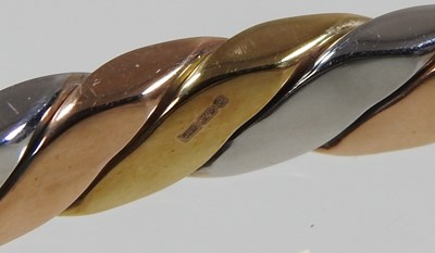 Lot 35 - A 9 carat three colour gold bangle, of hinged...