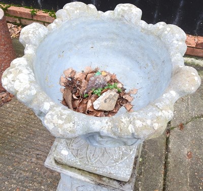 Lot 5 - A cast stone garden urn, on a plinth base,...