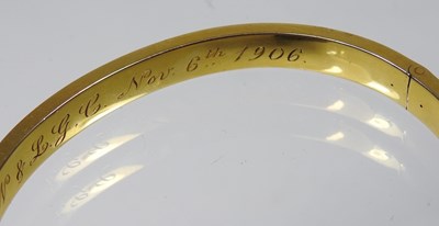 Lot 1 - An Edwardian 14 carat gold bangle, of hinged...