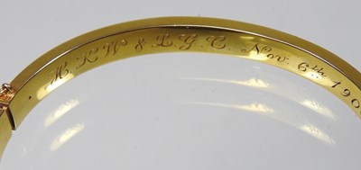 Lot 1 - An Edwardian 14 carat gold bangle, of hinged...