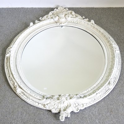 Lot 517 - A large oval wall mirror, with a moulded white...