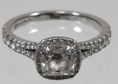 Lot 14 - A platinum and diamond halo ring, the central...