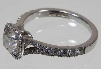 Lot 14 - A platinum and diamond halo ring, the central...