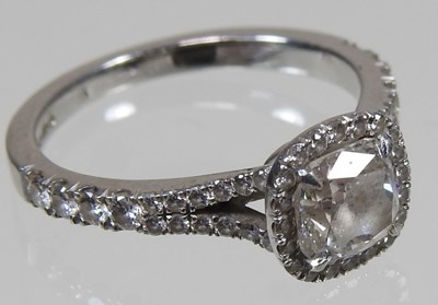 Lot 14 - A platinum and diamond halo ring, the central...