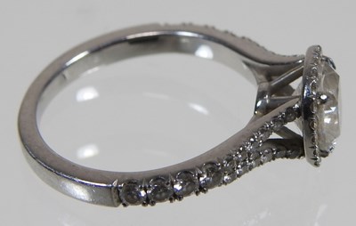 Lot 14 - A platinum and diamond halo ring, the central...