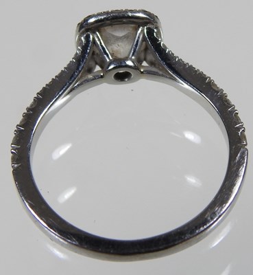 Lot 14 - A platinum and diamond halo ring, the central...