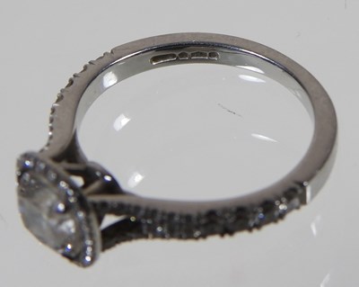 Lot 14 - A platinum and diamond halo ring, the central...