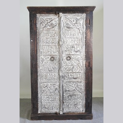 Lot 432 - An eastern limed hardwood cabinet, fitted with...