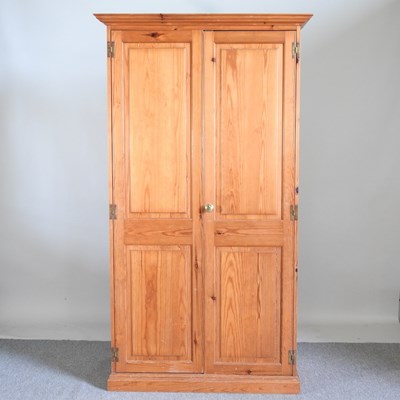 Lot 539 - A modern pine double wardrobe, enclosed by...