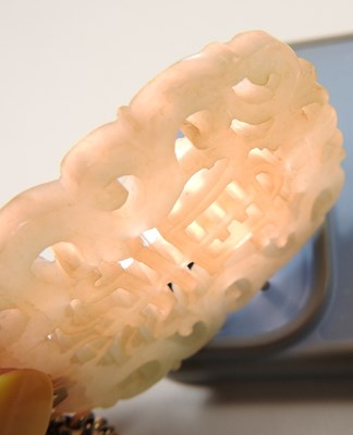Lot 42 - A Chinese jade pendant, fret carved with two...