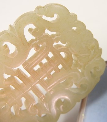 Lot 42 - A Chinese jade pendant, fret carved with two...