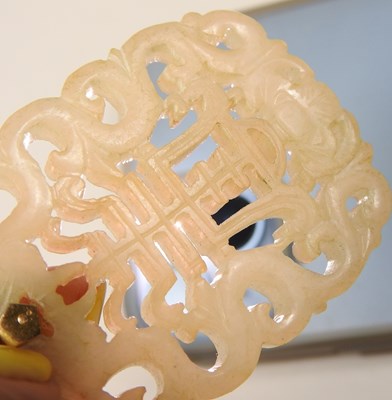 Lot 42 - A Chinese jade pendant, fret carved with two...