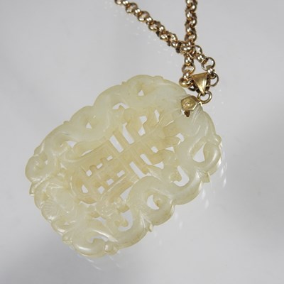 Lot 42 - A Chinese jade pendant, fret carved with two...