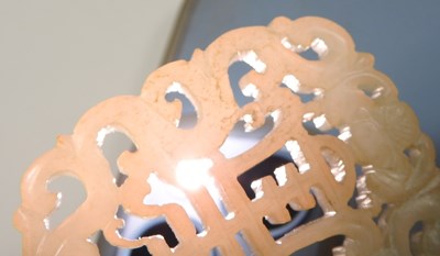 Lot 42 - A Chinese jade pendant, fret carved with two...
