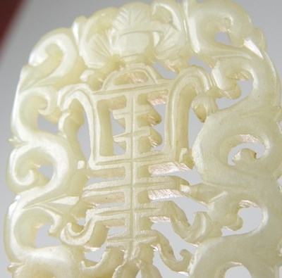 Lot 42 - A Chinese jade pendant, fret carved with two...