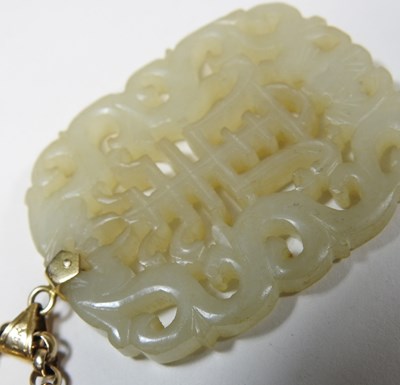 Lot 42 - A Chinese jade pendant, fret carved with two...