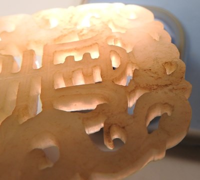 Lot 42 - A Chinese jade pendant, fret carved with two...