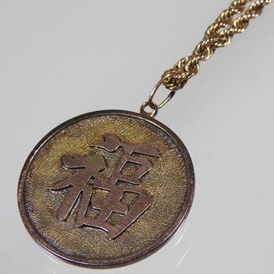 Lot 68 - A Chinese two colour gilt dragon coin pendant,...