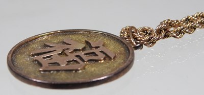 Lot 68 - A Chinese two colour gilt dragon coin pendant,...