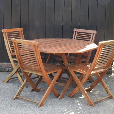 Lot 517 - A teak garden table and a set of four folding...