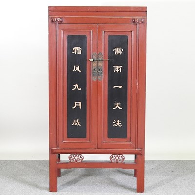 Lot 130 - A Chinese red painted side cabinet, decorated...