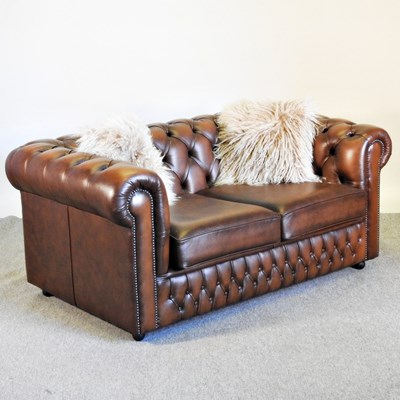 Lot 142 - A brown leather upholstered chesterfield sofa,...