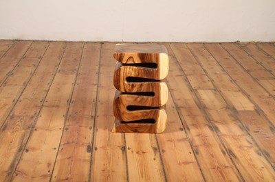 Lot 70 - An Indonesian carved teak stool, of a flowing,...