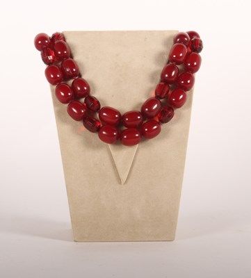 Lot 198 - A faux cherry amber barrel bead necklace and...
