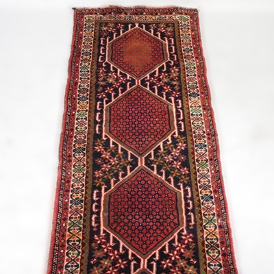 Lot 173 - A Persian runner, with a row of three hooked...