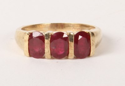 Lot 189 - A 9 carat gold three stone ruby ring, size P,...
