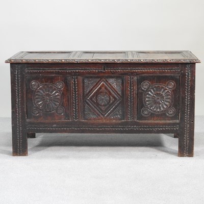Lot 215 - An 18th century carved oak coffer, with a...