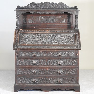 Lot 631 - A 19th century heavily carved dark oak bureau,...