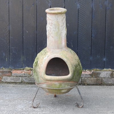 Lot 498 - A terracotta chiminea, on an iron base, 96cm high