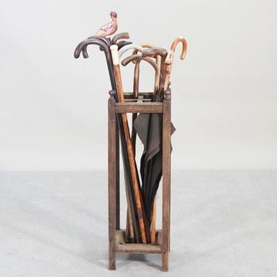 Lot 30 - A collection of walking sticks, in an oak...