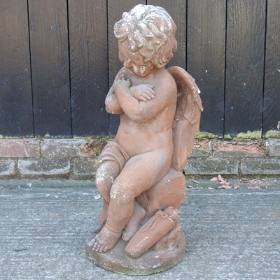 Lot 11 - A terracotta garden statue of a winged cherub,...