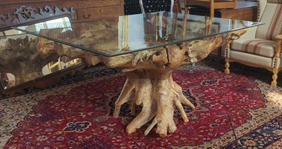Lot 495 - A square glass table on a carved teak rootwood...