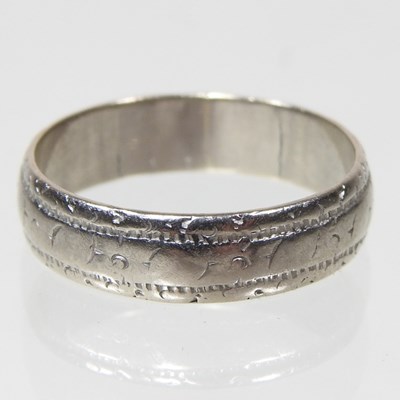Lot 207 - An 18 carat white gold wedding band, with...