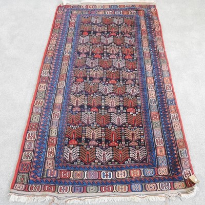 Lot 677 - A Baluch carpet, with coloured motifs, within...