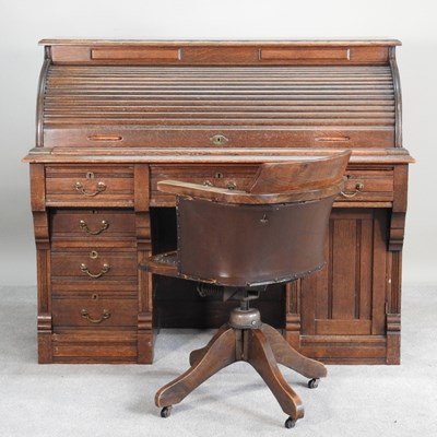 Lot 146 - A 1920s oak tambour top oak kneehole desk,...