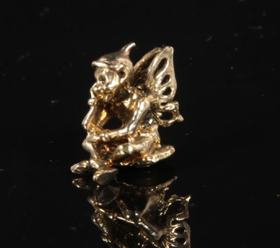 Lot 117 - A yellow metal figure of a seated pixie,...