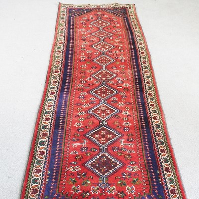 Lot 554 - A Persian runner, with a row of central...