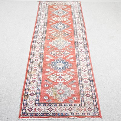 Lot 230 - A Persian kazak runner, with a row of hooked...