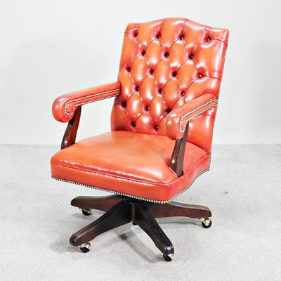 Lot 72 - A red leather upholstered button back swivel...