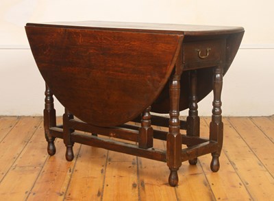 Lot 313 - An antique oak drop leaf gateleg dining table