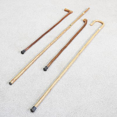 Lot 697 - A collection of four various wooden walking...