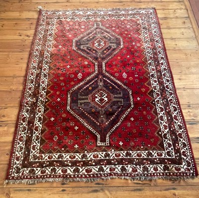 Lot 455 - A Persian rug, decorated with motifs on a red...