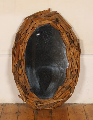 Lot 576 - A modern oval wall mirror, mounted with driftwood